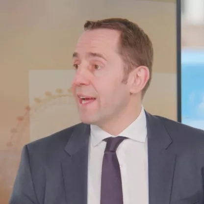 screengrab from interview with David Harrison for Asset TV dressed in suit in television studio