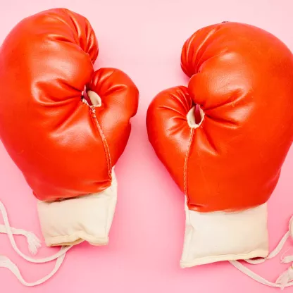 Red boxing gloves on pink background